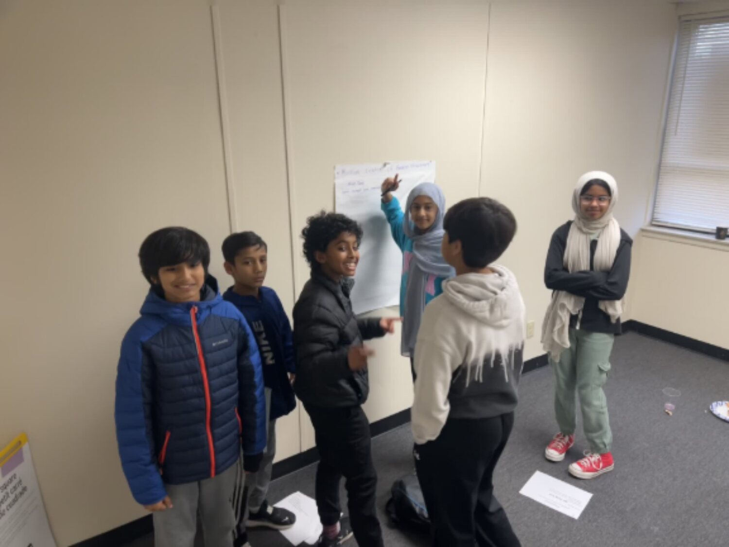 A team of young participants collaborating at a wall during a problem-solving exercise